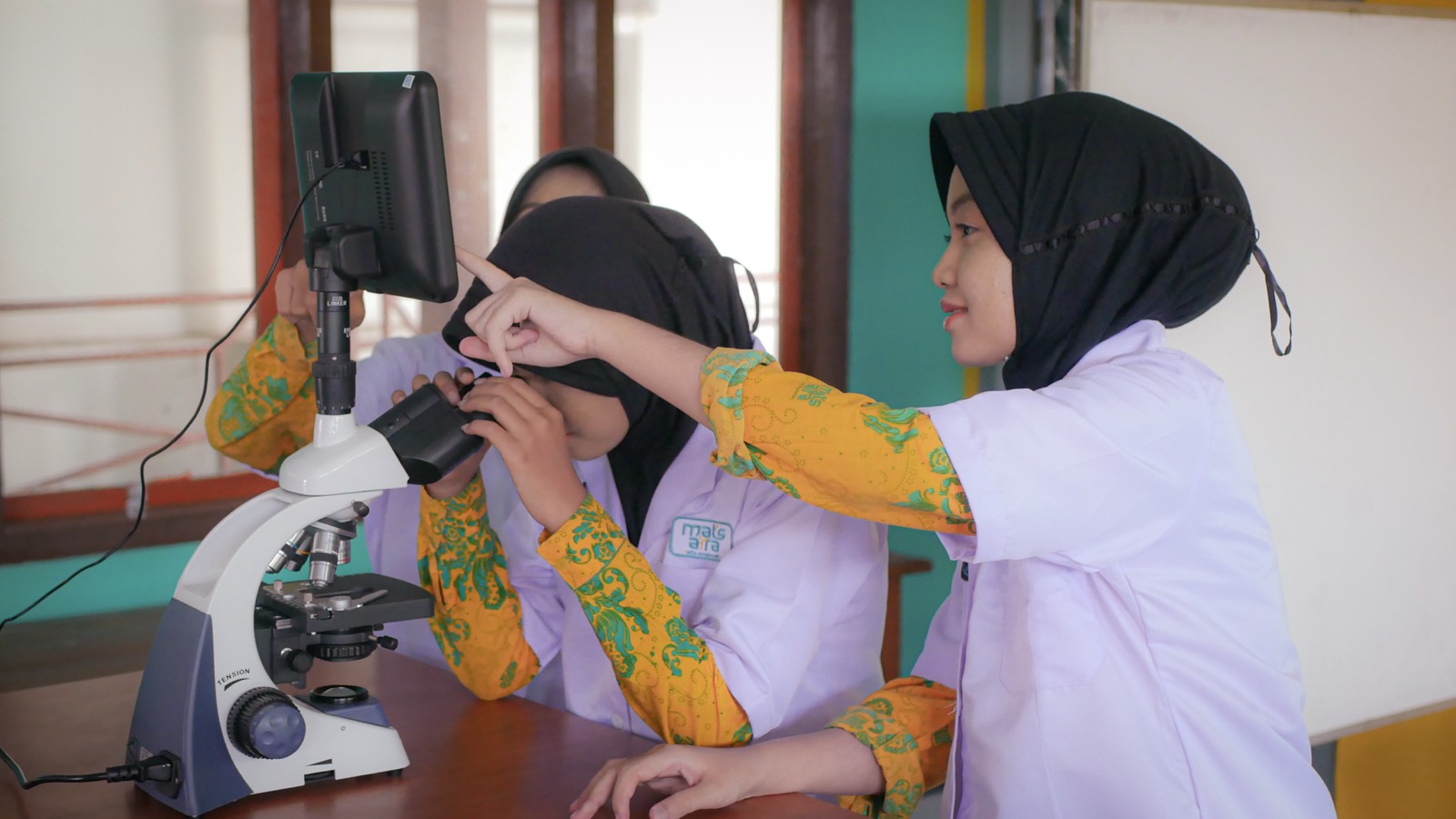 Siswi mengamati preparat dengan mikroskop digital di laboratorium IPA