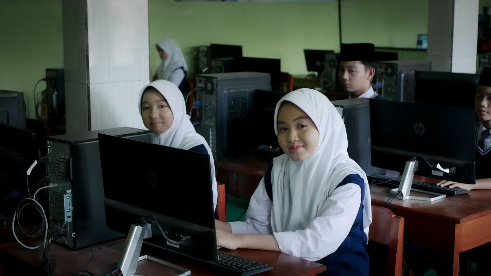 Siswi belajar desain di laboratorium komputer